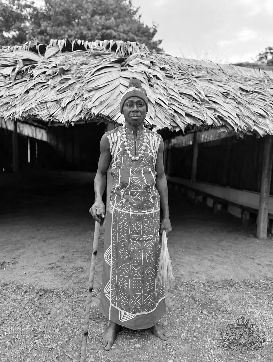 Jérôme Mouele Niangou devant le temple en tenue rituelle, photographie en noir et blanc