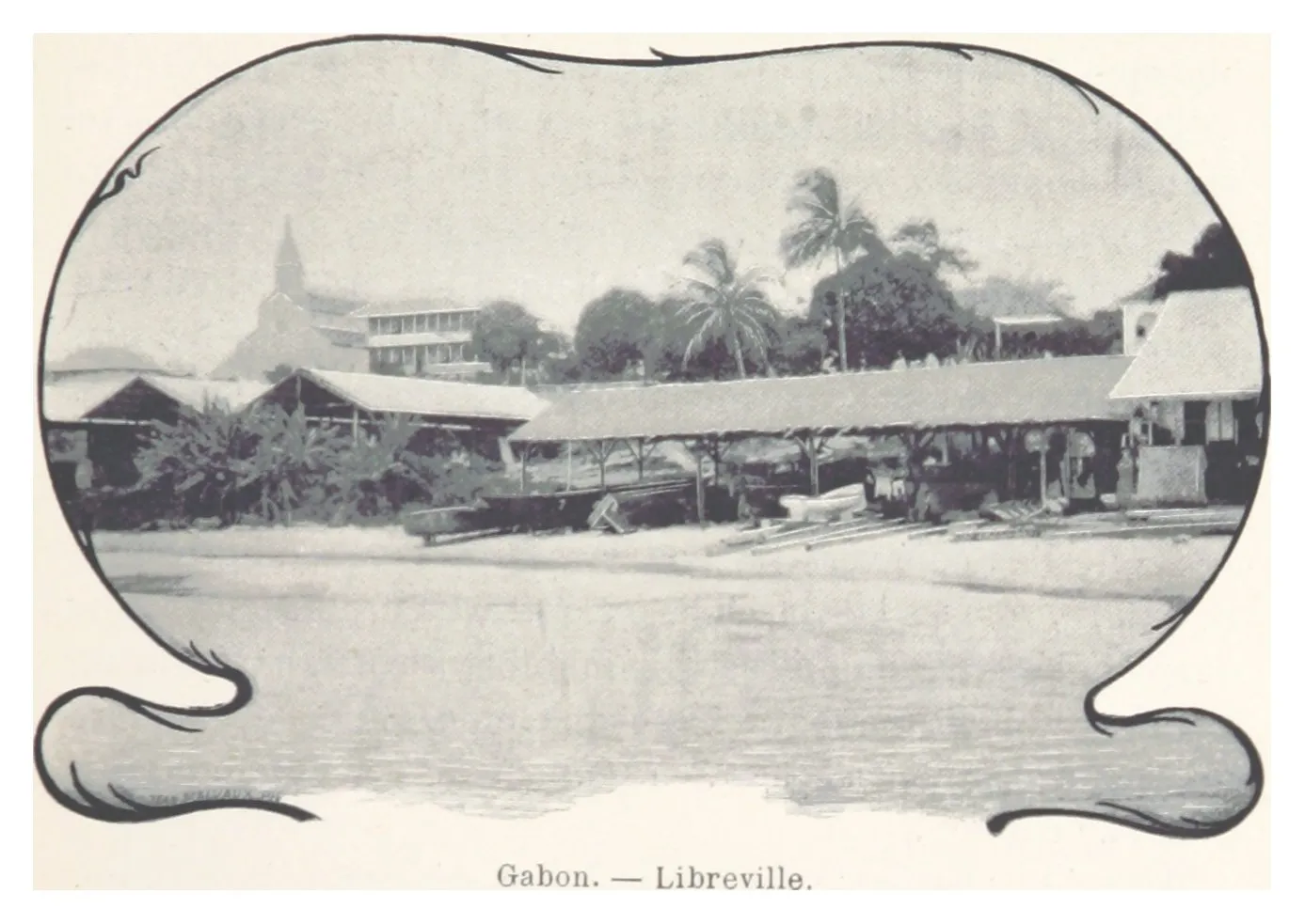 Photographie ancienne : le rivage de Libreville, des hangars de commerce et un clocher au-dessus des toits, des pirogues sur la plage