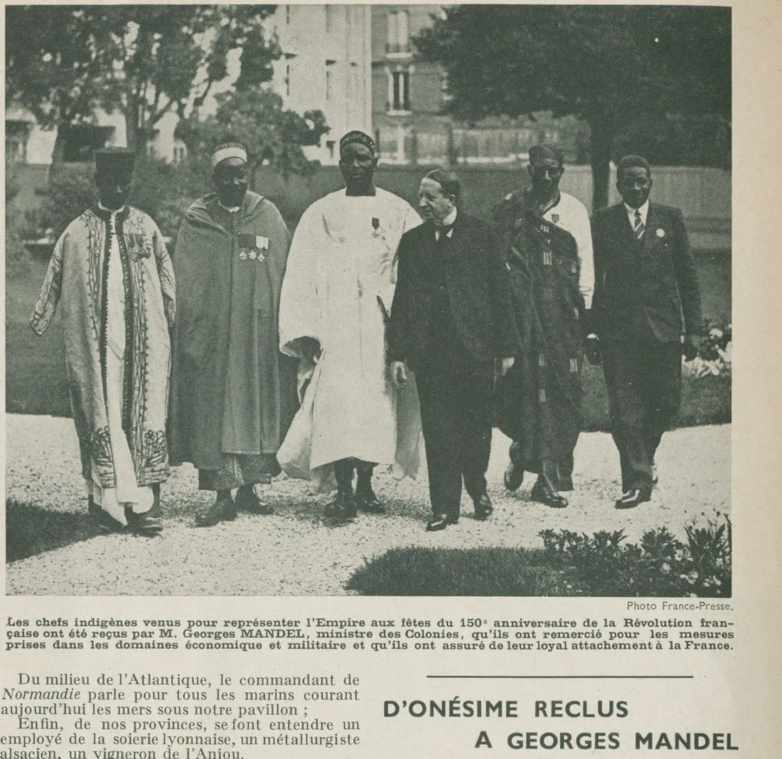 Photographie de 1939 : des chefs venus de l'Empire marchent dans un jardin aux côtés du ministre Georges Mandel